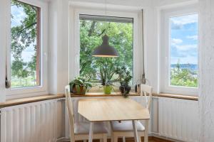 a dining room with a table and two windows at Rotes Haus über den Weinbergen in Konstanz