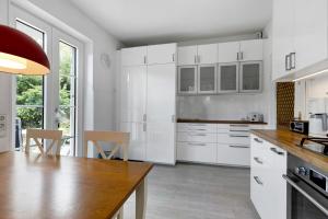 a kitchen with white cabinets and a table and chairs at Rotes Haus über den Weinbergen in Konstanz +22 photos