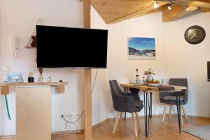 a television on a stand in a room with a table at Ferienwohnung Wendelinus in Rettenberg