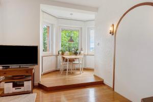 a living room with a television and a dining room table at Rotes Haus über den Weinbergen in Konstanz