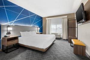 a hotel room with a bed and a tv at Comfort Suites Fort Wayne North in Fort Wayne +38 photos