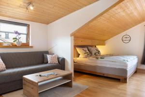a bedroom with a bed and a couch in a room at Ferienwohnung Wendelinus in Rettenberg