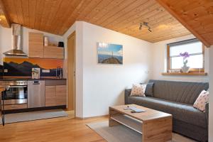 a living room with a couch and a table at Ferienwohnung Wendelinus in Rettenberg