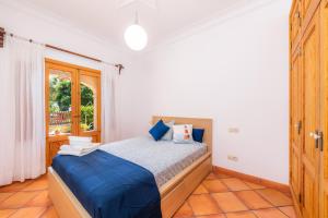a bedroom with a bed with blue sheets and a window at Ca Na Rosa in Alcudia +29 photos