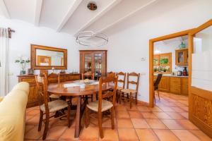 a kitchen and dining room with a wooden table and chairs at Ca Na Rosa in Alcudia