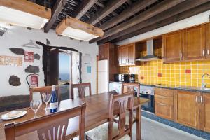 a kitchen with wooden cabinets and a table with chairs at El Lagar in Frontera