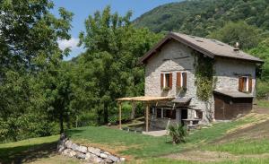a small stone house on a hill with trees at Nini's Home in Schignano