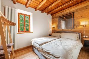 a bedroom with a bed and a wooden wall at Nini's Home in Schignano