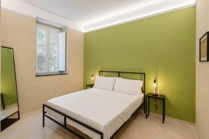 a bedroom with a bed and a green wall at Dimora Borgo Antico Lucia in Ascea