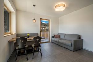 a living room with a couch and a table and chairs at sunnig Apartment Sonnenlicht in Vollan
