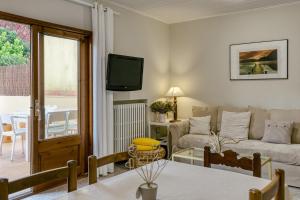 a living room with a couch and a tv at Casa adosada in Begur