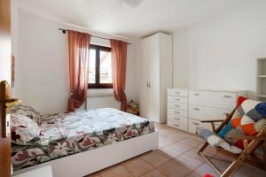 a bedroom with a bed and a chair and a window at Villino Flora a Viareggio in Viareggio