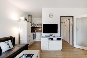 a living room with a couch and a flat screen tv at Ostseeperle mit Schwimmbad in Dahme