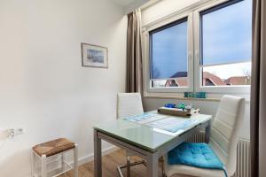 a dining room with a table and chairs and a window at Ostseeperle mit Schwimmbad in Dahme