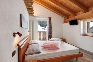 a bedroom with a bed and a window at Casa Nicoletta inverno in Livigno