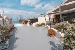 a balcony with potted plants on a building at Rody Caves Oia in Oia +85 photos