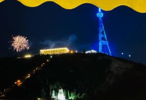 a tower on top of a hill with fireworks at Kazma Boutique Hotel in Tbilisi City