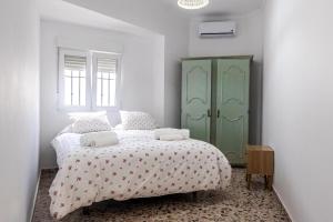a bedroom with a bed and a green cabinet at Santa Clara Home in Marchena