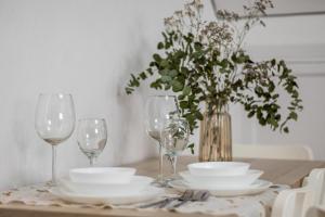 a table with glasses and plates and a vase with flowers at Santa Clara Home in Marchena