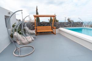 a porch with a swing and a swimming pool at Rody Caves Oia in Oia