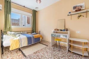 a bedroom with a bed and a desk and a window at Little Alhambra in Dúrcal