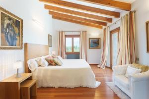 a bedroom with a white bed and a couch at Villa Golf Marina Premium in Pollença +26 photos