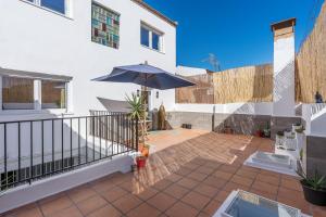 a patio with an umbrella on a balcony at Little Alhambra in Dúrcal