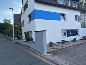 a white house with potted plants on the side of it at Mini Apartment in Bayreuth