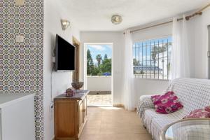 a living room with a couch and a tv at Complejo Alejandra in Conil de la Frontera