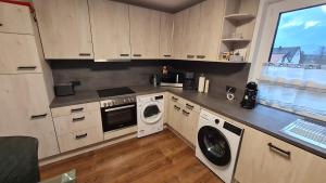 a kitchen with a washing machine and a washer and dryer at Ferienwohnung Helfensteinblick in Calden