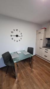 a room with a table and a clock on the wall at Ferienwohnung Helfensteinblick in Calden +4 photos