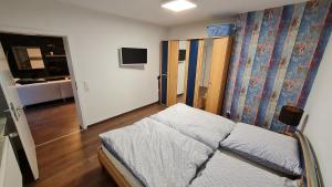a small bedroom with a bed and a room with a bed sqor at Ferienwohnung Helfensteinblick in Calden