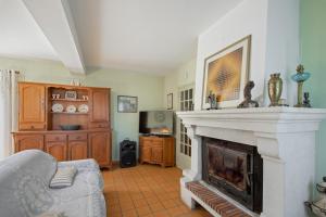 a living room with a fireplace and a couch at Domaine du Courroussouve in Oppède