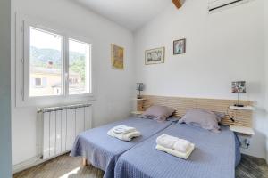 a bedroom with a blue bed with two towels on it at Domaine du Courroussouve in Oppède +24 photos