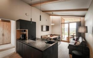 a kitchen and living room with a table and a couch at Oberplunerhof Luxury Chalet Skyline in Chienes