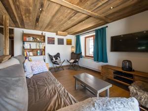 a living room with a couch and a flat screen tv at Gite Le Mazot in Albiez-Montrond