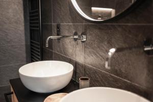 a bathroom with a white sink and a mirror at Oberplunerhof Luxury Chalet Skyline in Chienes +37 photos