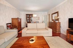 a living room with two white couches and a tv at Seaside Escape in Funchal