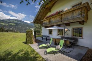 a patio with a table and chairs in front of a house at Oberplunerhof Luxury Chalet Skyline in Chienes