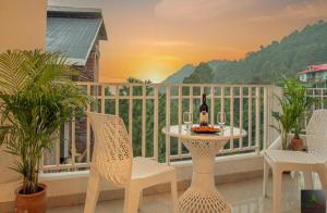 a table with a bottle of wine on a balcony at Himalayan Mist Retreat By Cloud Berry stays kasauli in Dharampur