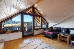 a living room with a couch and a large window at Ferienwohnung Panoramablick in Lenzkirch