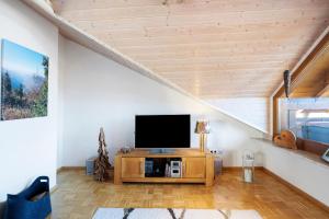 a living room with a flat screen tv on a wooden cabinet at Ferienwohnung Panoramablick in Lenzkirch