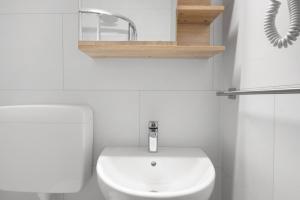 a white bathroom with a toilet and a sink at Marilleva 900 Kristall in Mezzana +21 photos