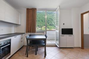 a kitchen with a table and a television and a window at Marilleva 900 Kristall in Mezzana