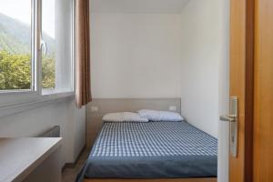 a small bed in a room with a window at Marilleva 900 Kristall in Mezzana