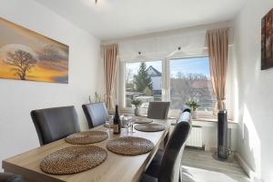 a dining room table with chairs and a large window at Fewo Zeitzauber in Marsberg +18 photos