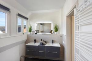 a bathroom with two sinks and a mirror at Fewo Zeitzauber in Marsberg
