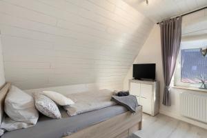 a room with a bed and a television in it at Fewo Zeitzauber in Marsberg