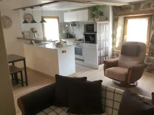 a living room with a couch and a kitchen at Appartement de charme Saint-Romain in Saint-Romain +12 photos