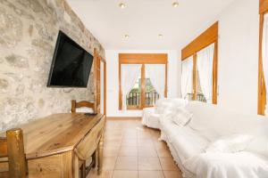 a living room with two white couches and a tv at Casa ponet in Solsona
